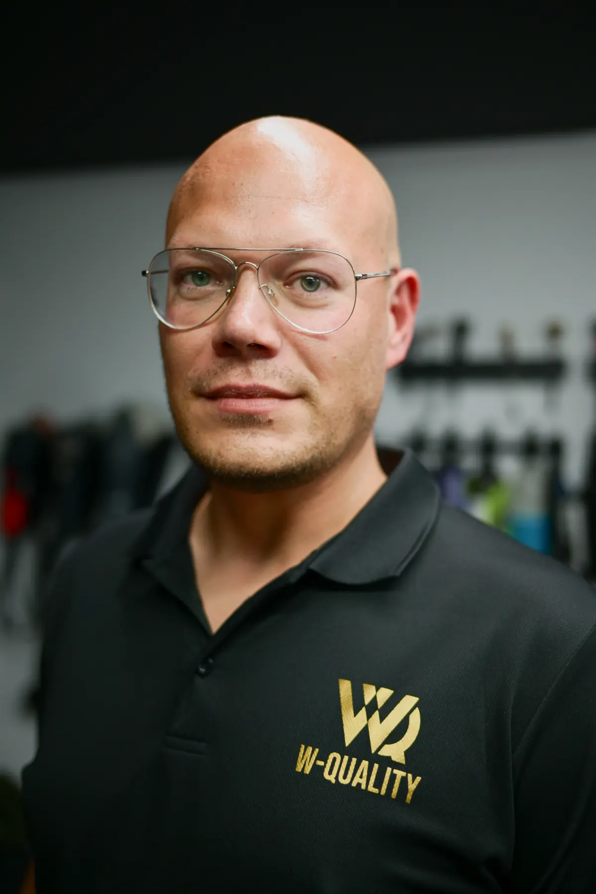 Portret Bartosza Wróblewskiego w czarnej koszulce polo z logo W-Quality