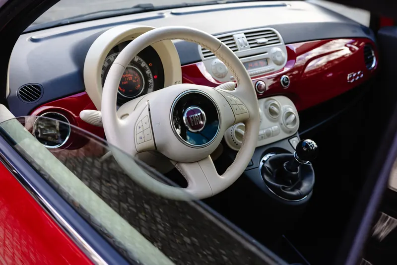 Jasna kierownica i czerwony kokpit Fiata 500 po czyszczeniu